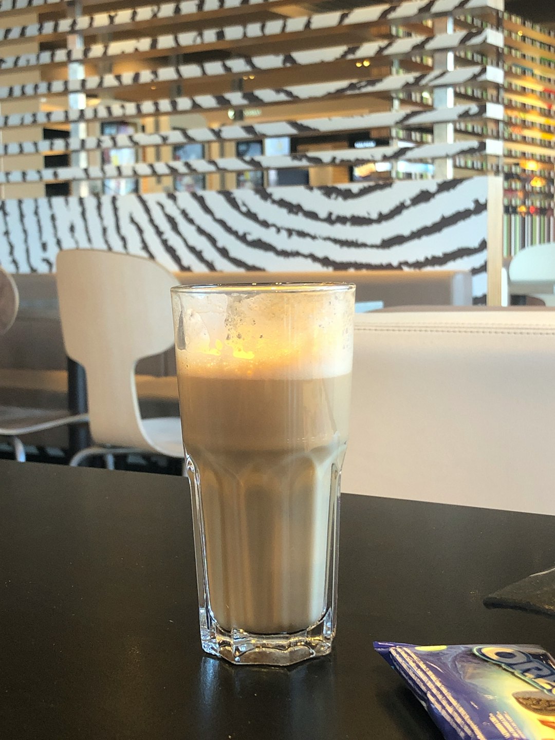 Café con leche en vaso de cristal en un establecimiento de McDonalds. Mccafe.
